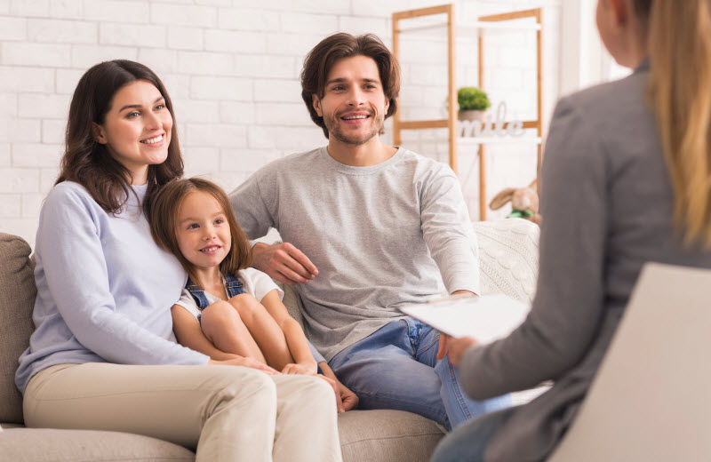 Cairns Paediatric Psychology - Communication between home and school Happy Parents With Little Daughter Sitting Together At Psycholigist's Office