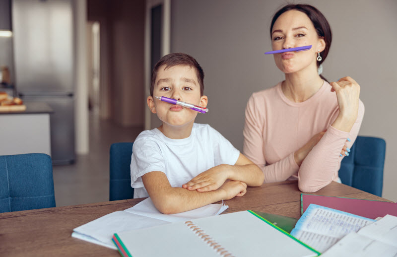 Cairns Paediatric Psychology - Curious children Pretty mother and cute son having fun and mocking faces with pens while studying