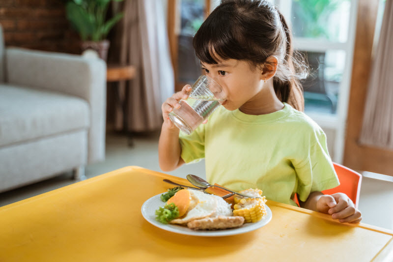 Cairns Paediatric Psychology - Establish consistent routines Child drinking while having healthy breakfast at home