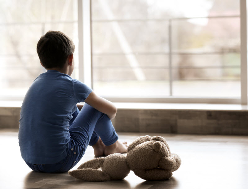 Cairns Paediatric Psychology - Important questions of grieving children Sad little boy sitting on floor facing the window