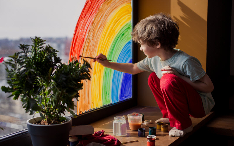 Cairns Paediatric Psychology - Online resources child at home draws a rainbow on the window.