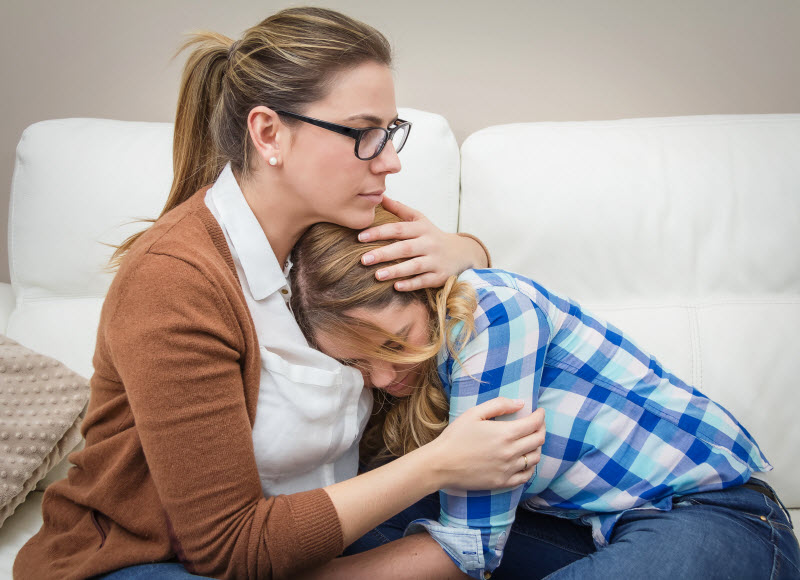 Cairns Paediatric Psychology - Provide soothing and comforting Mother embracing and soothes depressed teen daughter by problems
