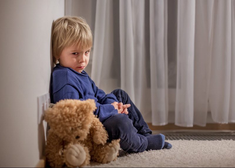 Cairns Paediatric Psychology - Reactions to Grief Angry little toddler child sitting in corner with teddy bear,