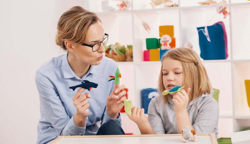 Cairns Paediatric Psychology - Reducing over-activity and fatigue Mother holding toys while playing with daughter at girl's room