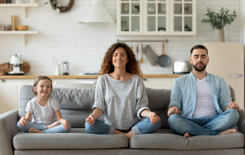 Cairns Paediatric Psychology - Relaxation skills happy parents with small preschooler girl child rest on sofa meditating