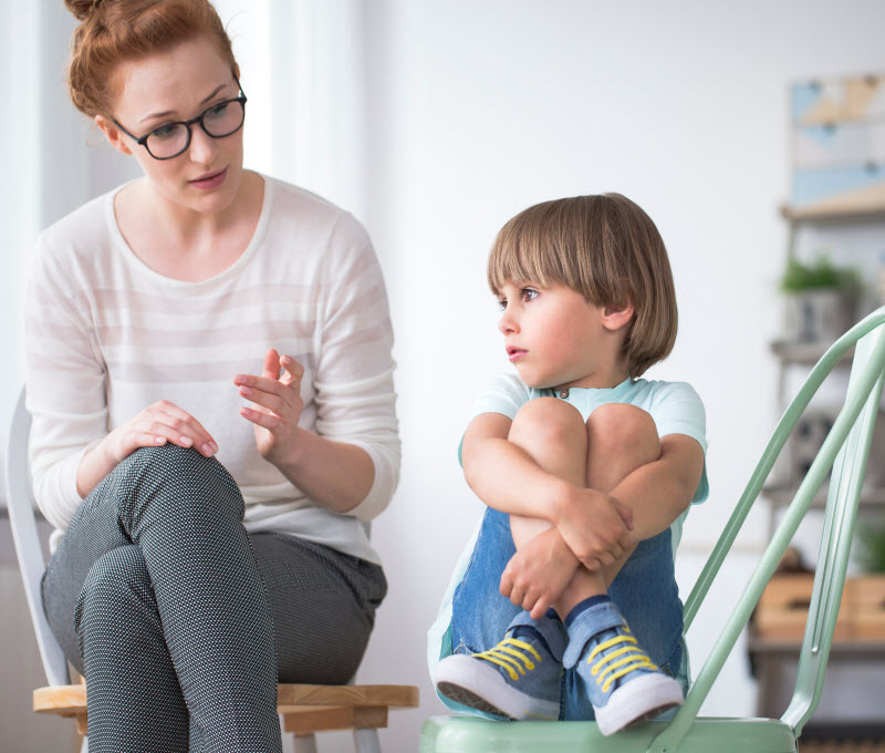 Cairns Paediatric Psychology - routine strategies Young boy listening to the woman while sitting on a chair